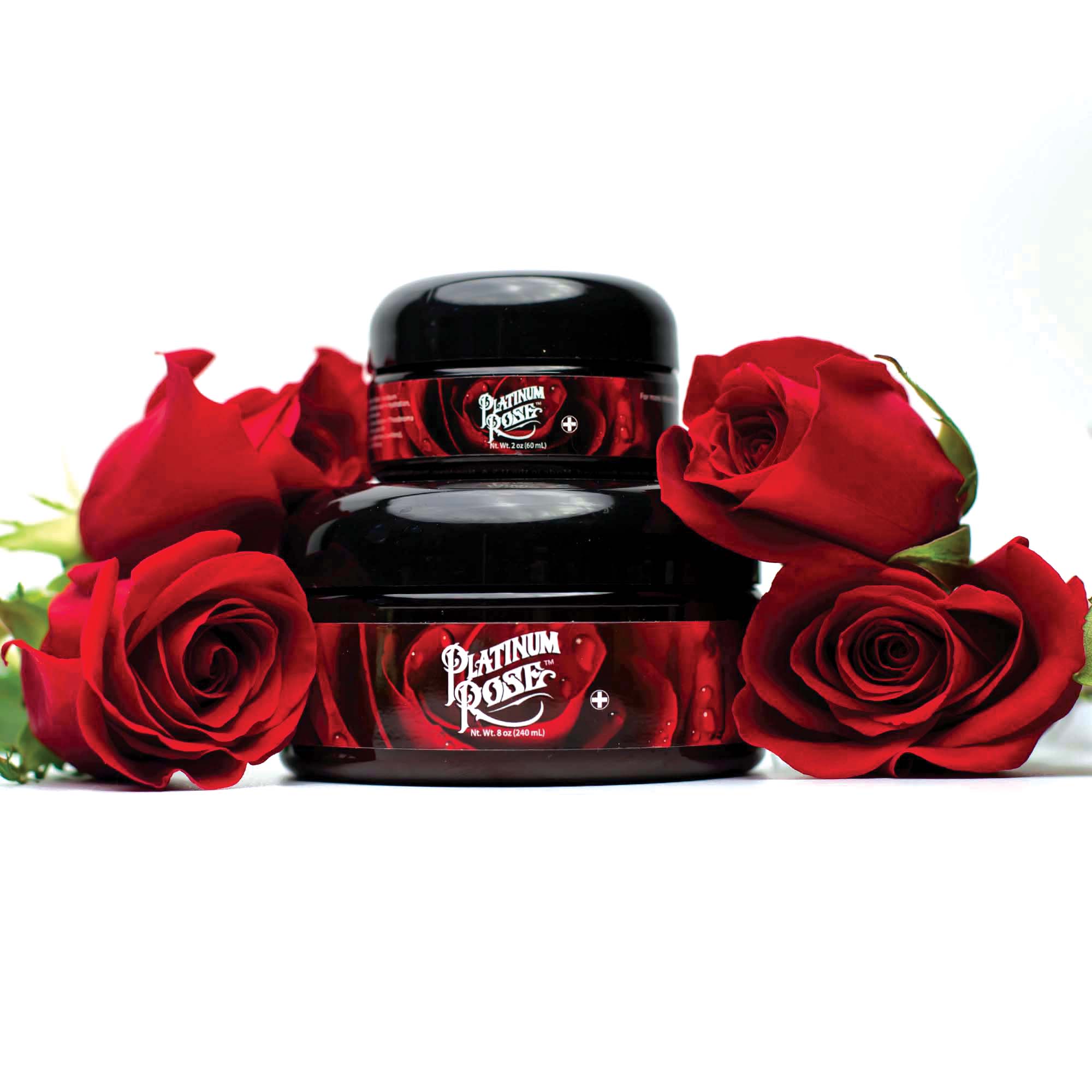 An 8oz Jar of rose scented Platinum Rose Tattoo Aftercare surrounded by freshly cut red roses